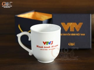 Cốc sứ dáng chóp lửa men trắng in logo Hành Trình 30 năm VTV3