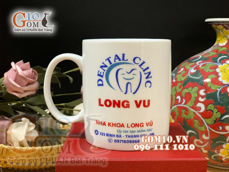 Cốc sứ quai tròn men trắng, in logo quà tặng Nha Khoa Long Vũ